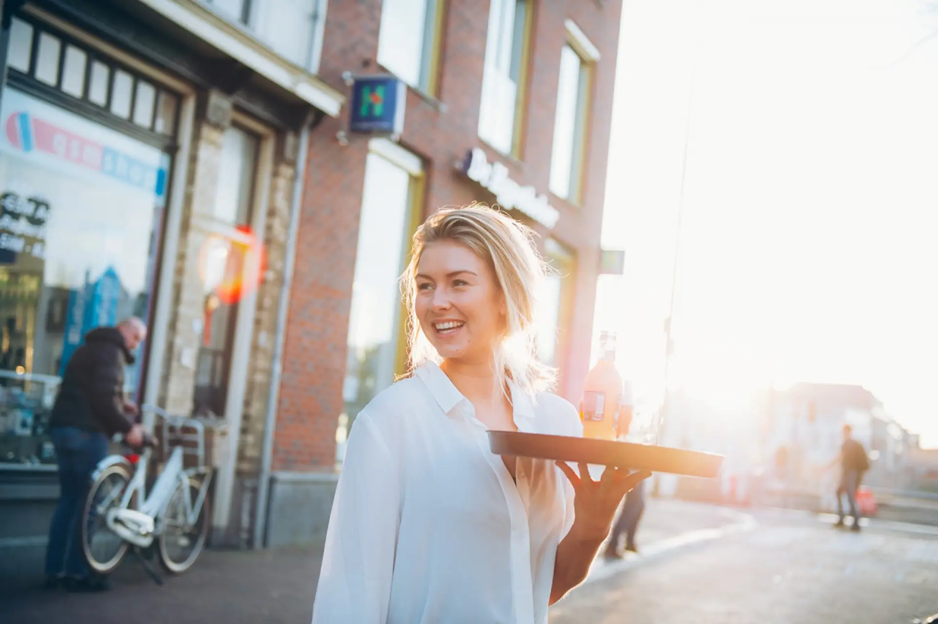 Lachende vrouwelijke ober met een dienblad