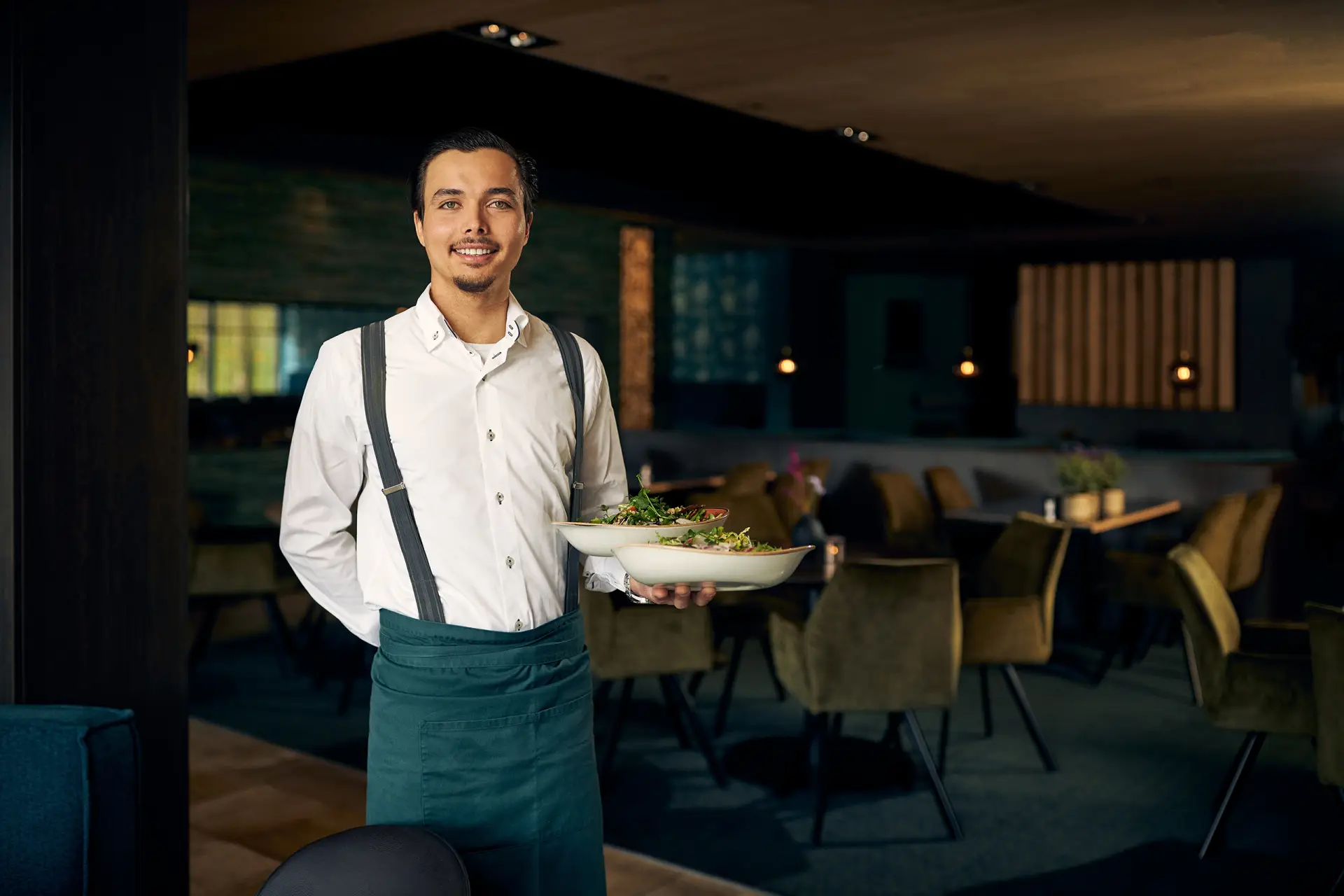 Mannelijke ober met een dienblad in een restaurant